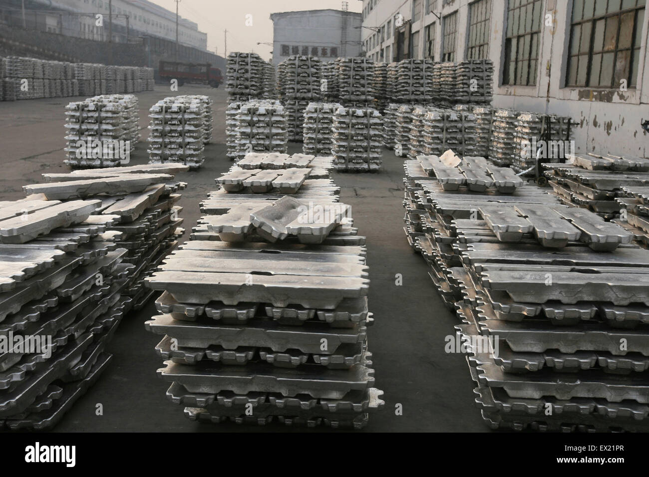 Labourers transport aluminium ingots at a storage of aluminium plant in