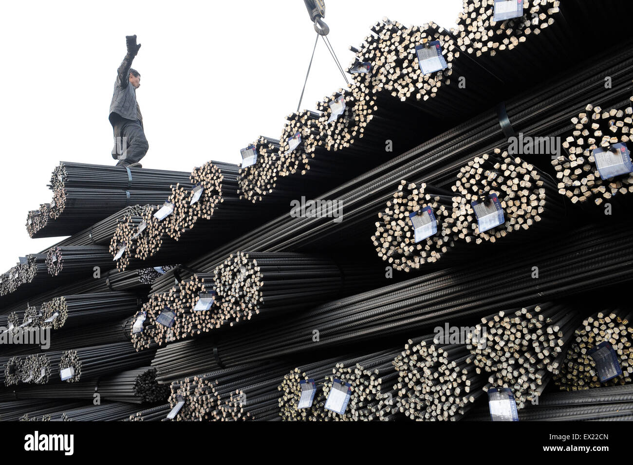 A labourer prepares for transporting bundles of steel bars at a steel