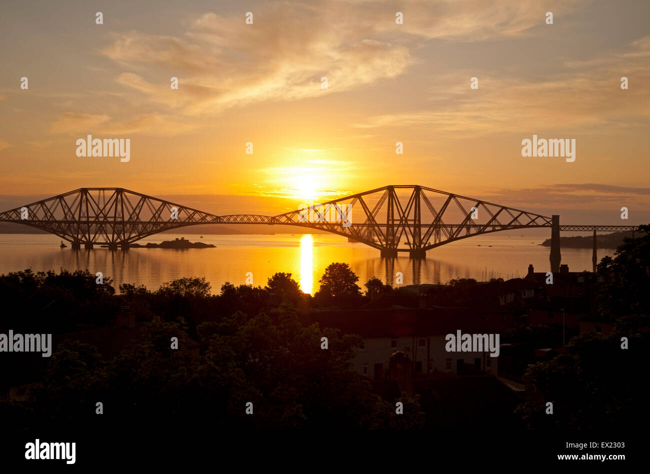 South Queensferry, Edinburgh, Scotland. 5th July, 2015. As the sun rises behind the Forth Rail Bridge the meeting that was underway in Bonn to decide whether the Forth Rail Bridge should become one of Scotland’s Unesco World Heritage Sites, it has been announced that the inspectors have decided that the structure should be recommended for approval, describing it as an “extraordinary milestone in the history of bridge construction”. Members of the UN’s heritage committee began their three day meeting in Germany on 3rd July. Stock Photo