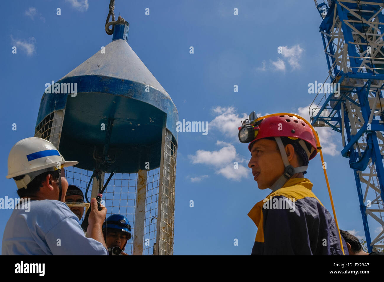Speleology enthusiasts and a journalist boarding a vertical construction lift for an excursion to the Bribin underground water project in Indonesia. Stock Photo