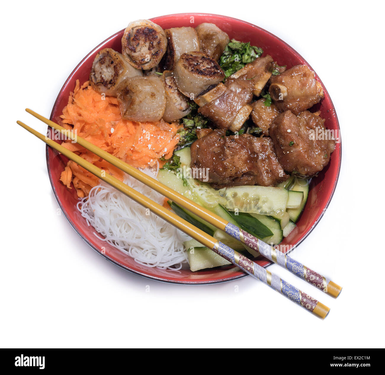 Bowl of beef Bo bun with salad, porc ribs, fresh herbs and chinese chopsticks Stock Photo