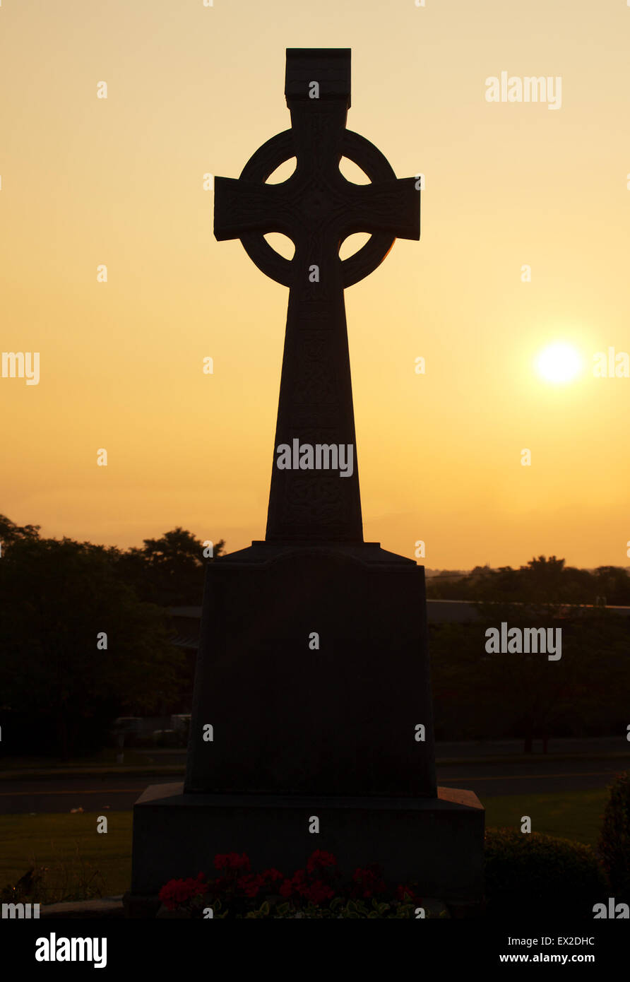 Celtic cross in silhouette on Tipperary Hill, a predominantly Irish- American suburb of Syracuse, New York Stock Photo