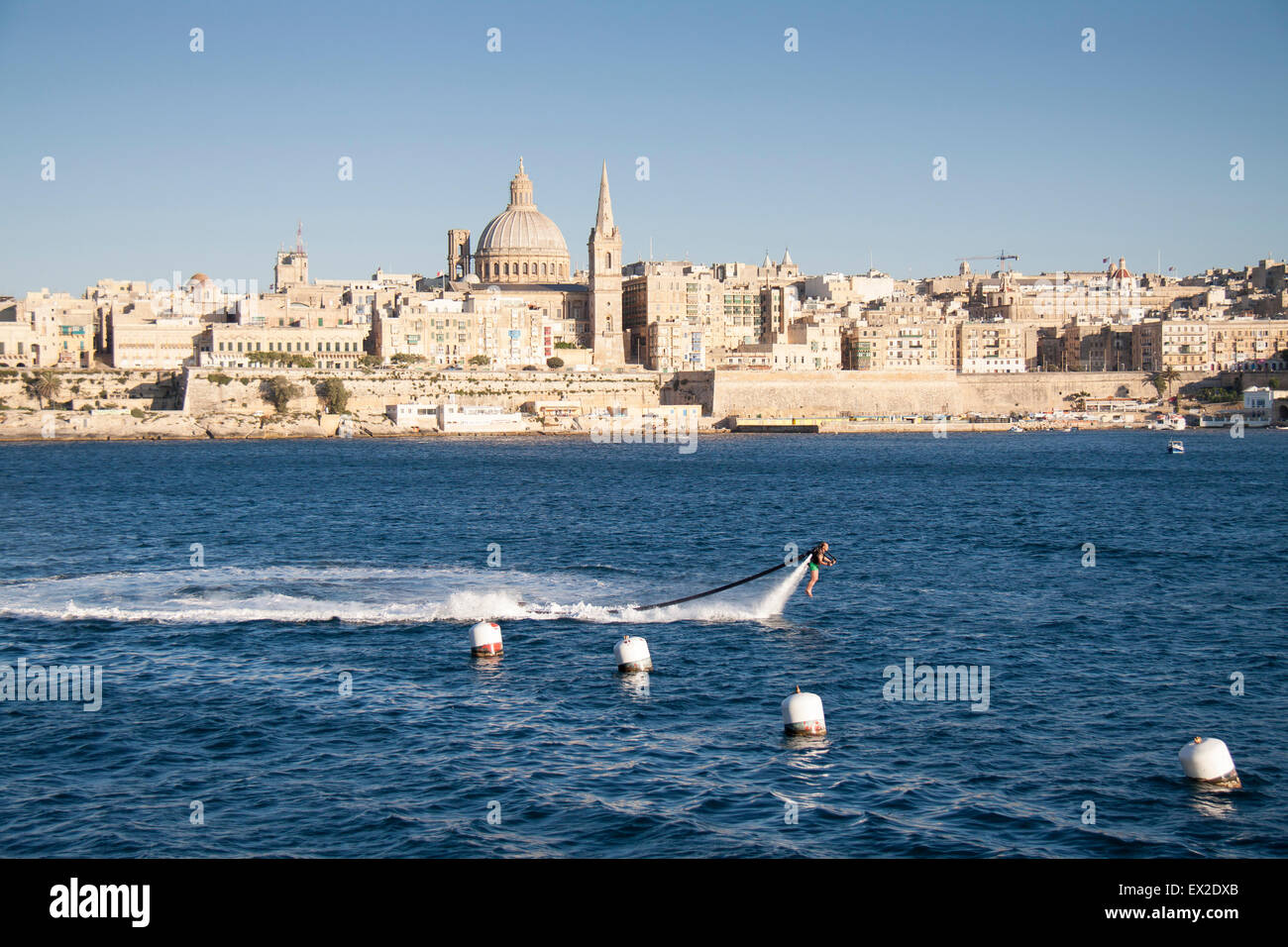 An innovative man plays with a jet pack in the waters between Valletta and Silema, Malta Stock Photo