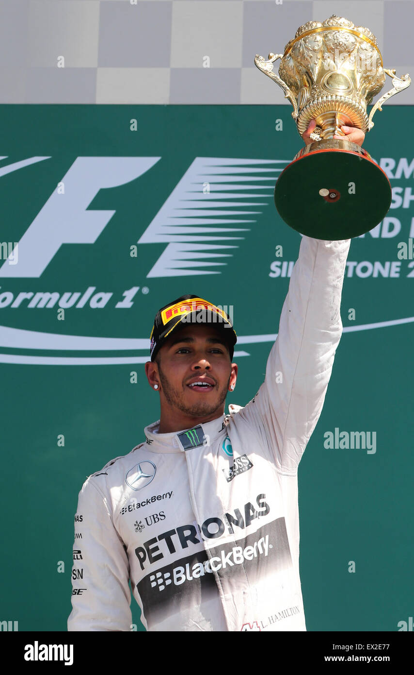 Silverstone, UK. 5th July, 2015. Britian's Lewis Hamilton of Mercedes Team celebrates with the trophy after 2015 Formula 1 British Grand Prix at Silverstone Circuit, Great Britain on July 5, 2015. Credit:  Han Yan/Xinhua/Alamy Live News Stock Photo