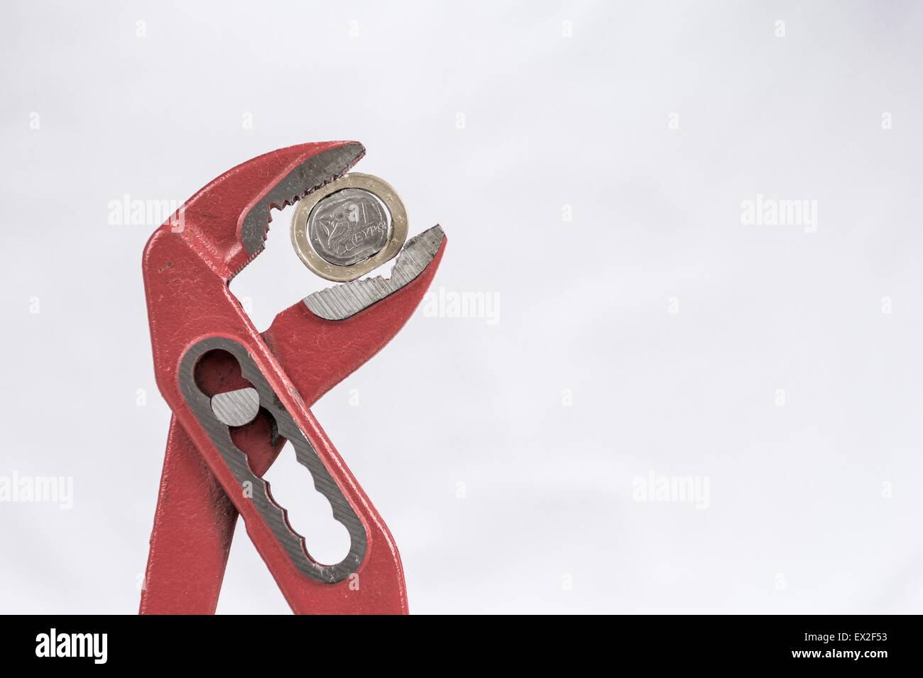 Greek Euro coin squezzed with pliers. Stock Photo