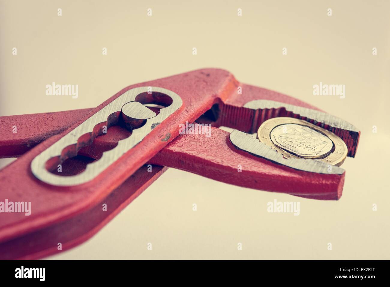 Greek Euro coin squezzed with pliers. Stock Photo
