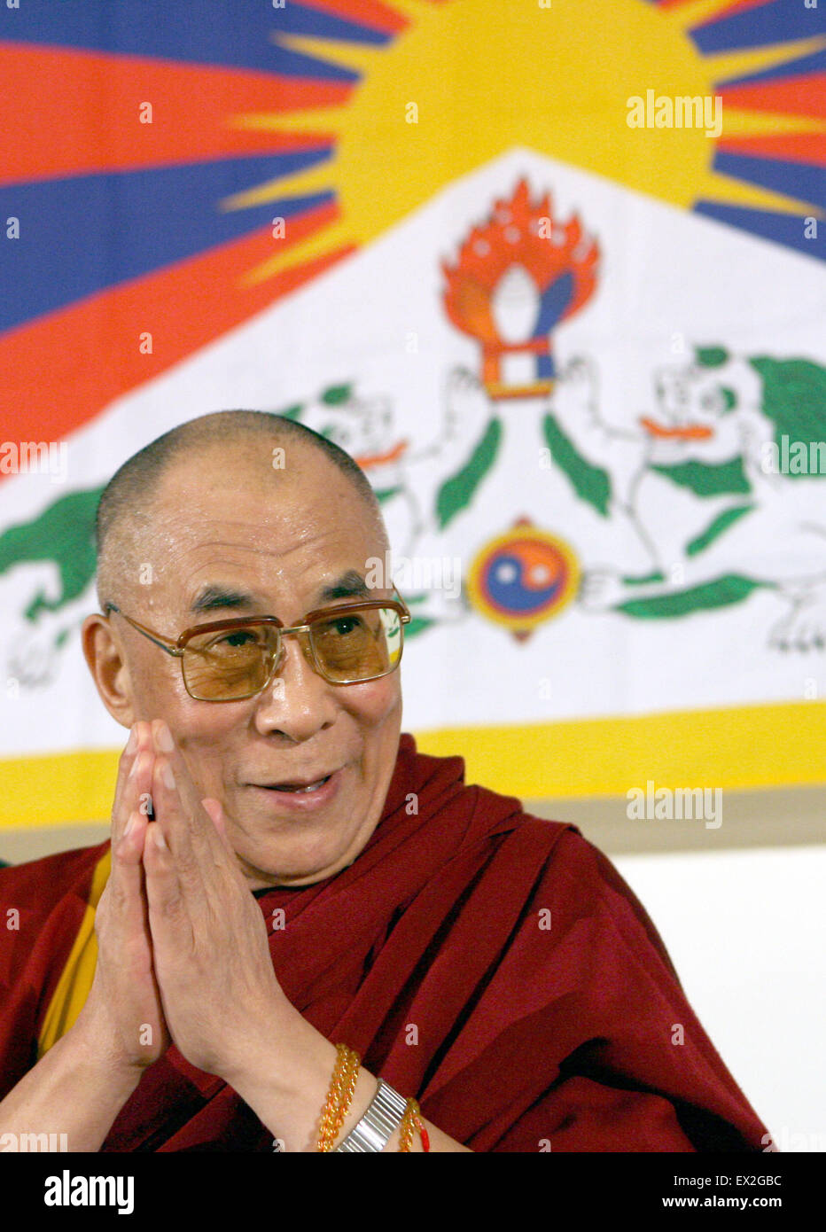 Bochum, Germany. 16th May, 2008. The Dalai Lama sits in front of a Tibetan flag and smiles during a press conference in Bochum, Germany, 16 May 2008. The spiritual and political leader of the Tibetan people is currently on a five-day-visit to Germany. Photo: FEDERICO GAMBARINI/dpa/Alamy Live News Stock Photo