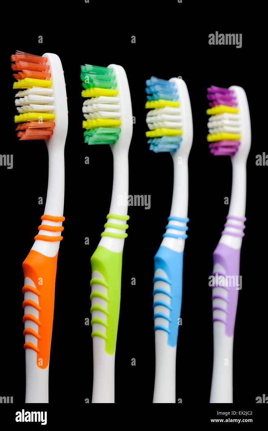 Four toothbrushes isolated on black Stock Photo - Alamy