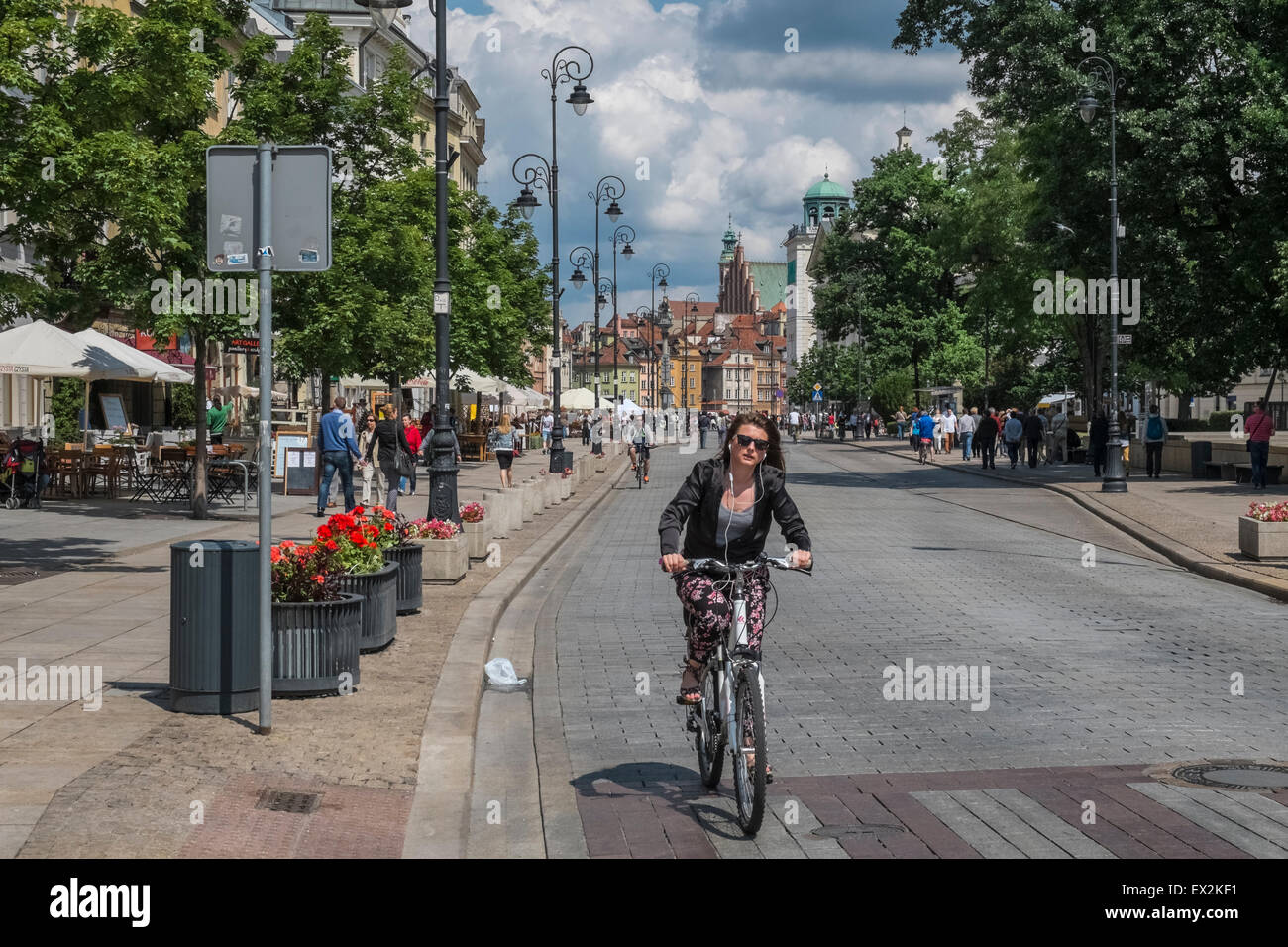 Young woman cycling on popular Krakowskie Przedmieście street, Old Town, Warsaw, Poland Stock Photo