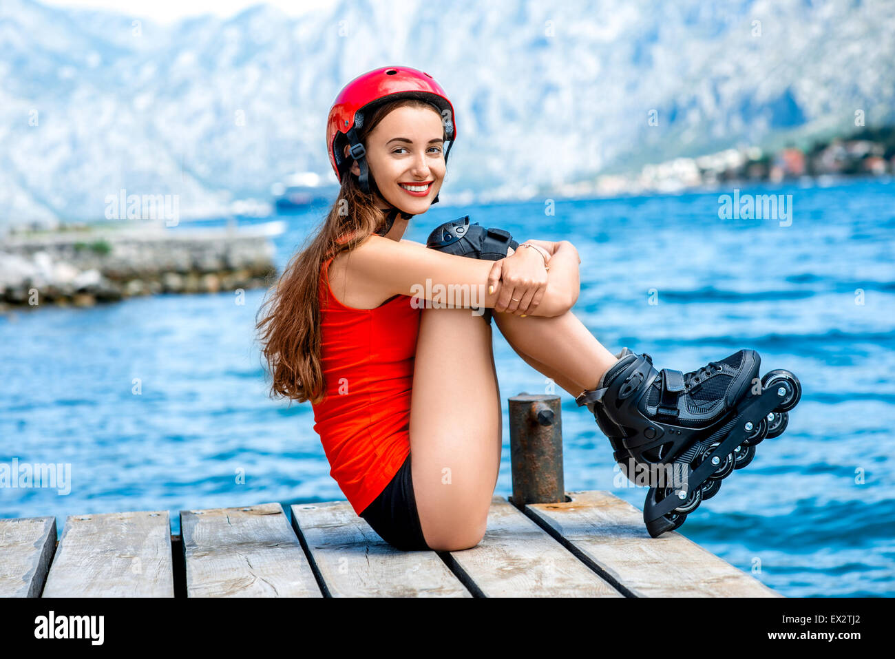 Woman in sportswear with skating rollers on the pier Stock Photo