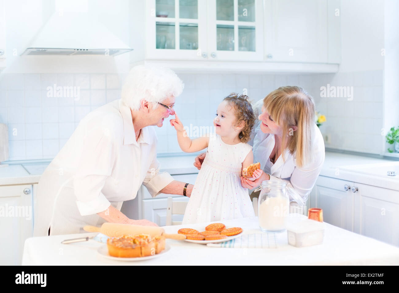 Funny toddler girl playing in a kitchen, having fun baking an apple pie