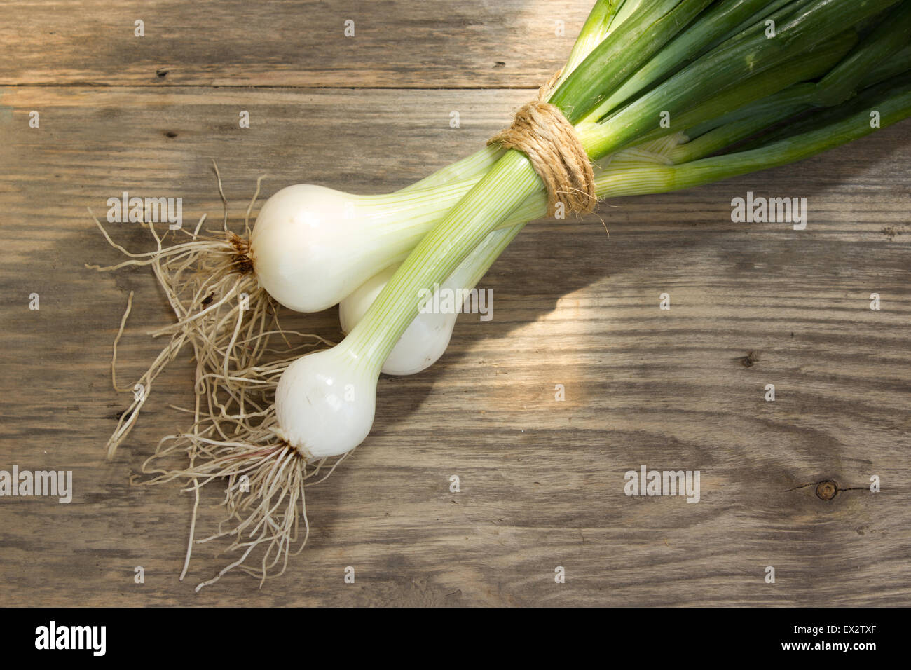 bunch of fresh green onions on wooden table Stock Photo - Alamy