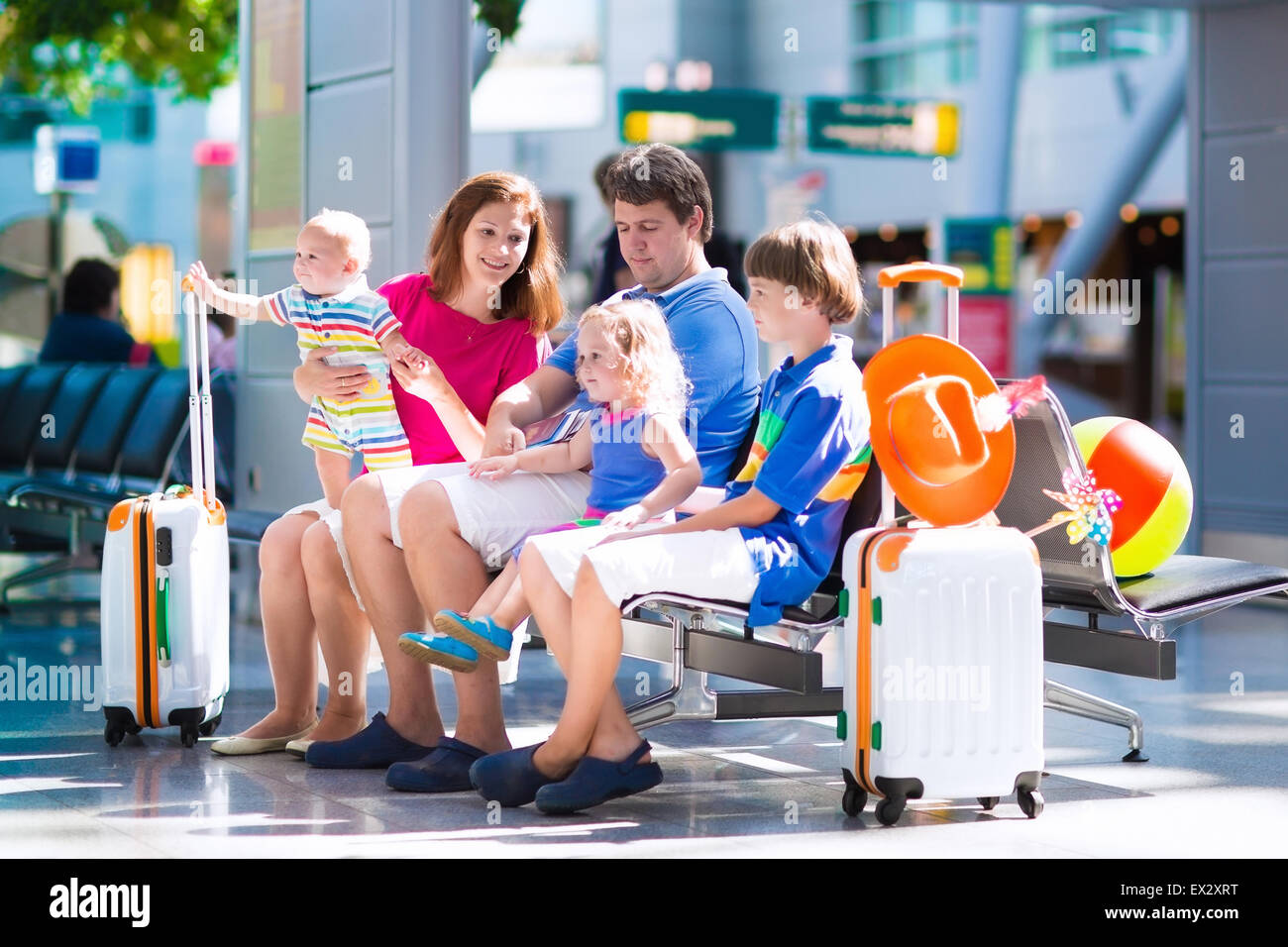 Family traveling with kids. Parents with children at international airport with luggage. Stock Photo