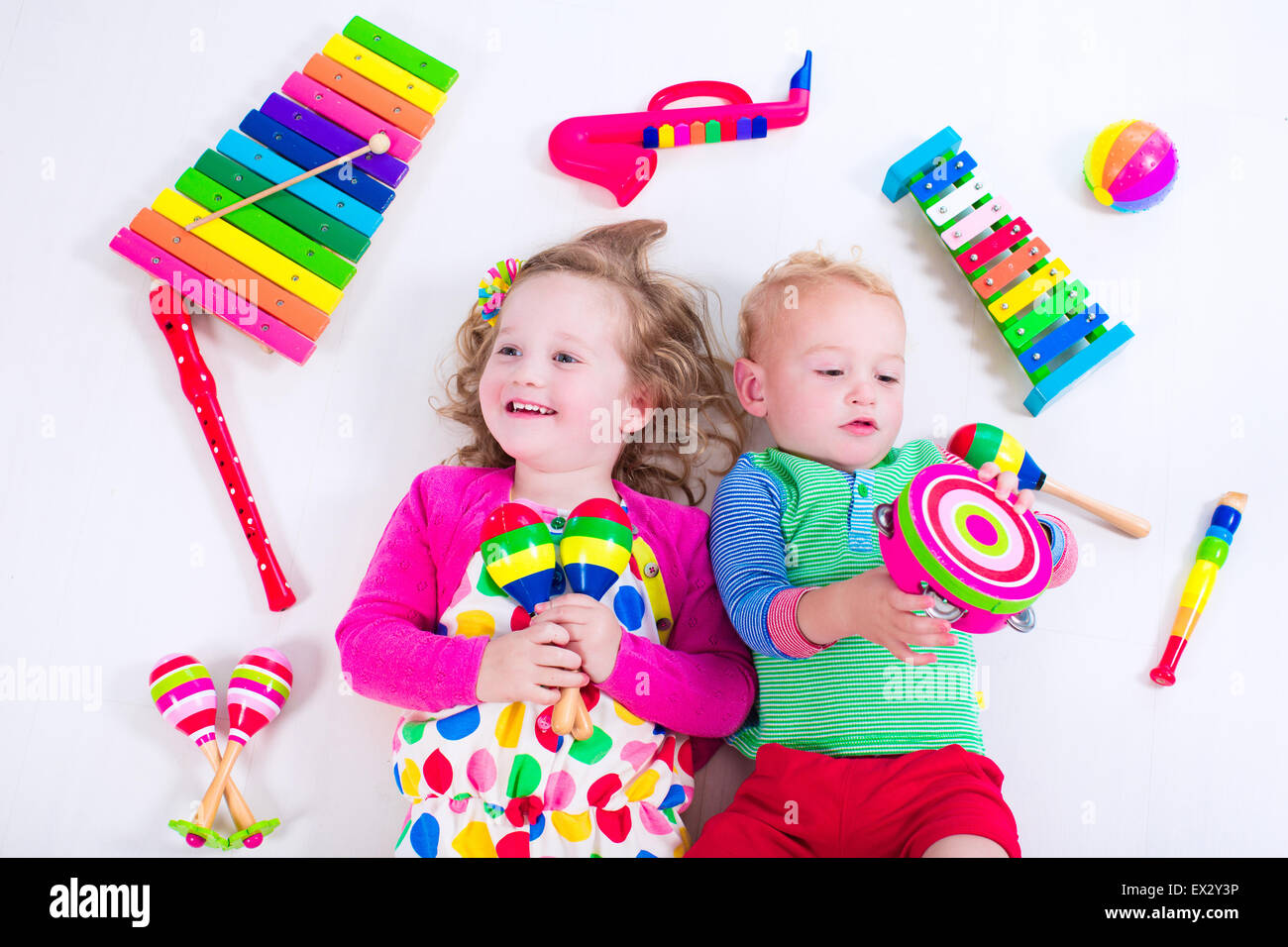 Child with music instruments. Musical education for kids. Colorful wooden art toys for kids. Little girl and boy play music. Stock Photo
