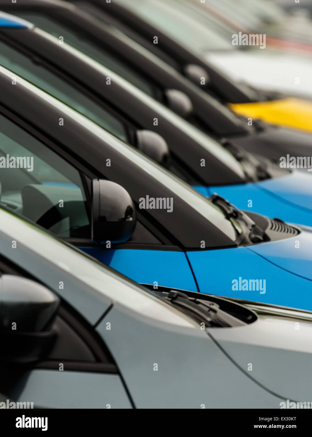 Vehicles for sale parked in a row with close up detail on the wing mirror without focus on any particular model making the cars  Stock Photo