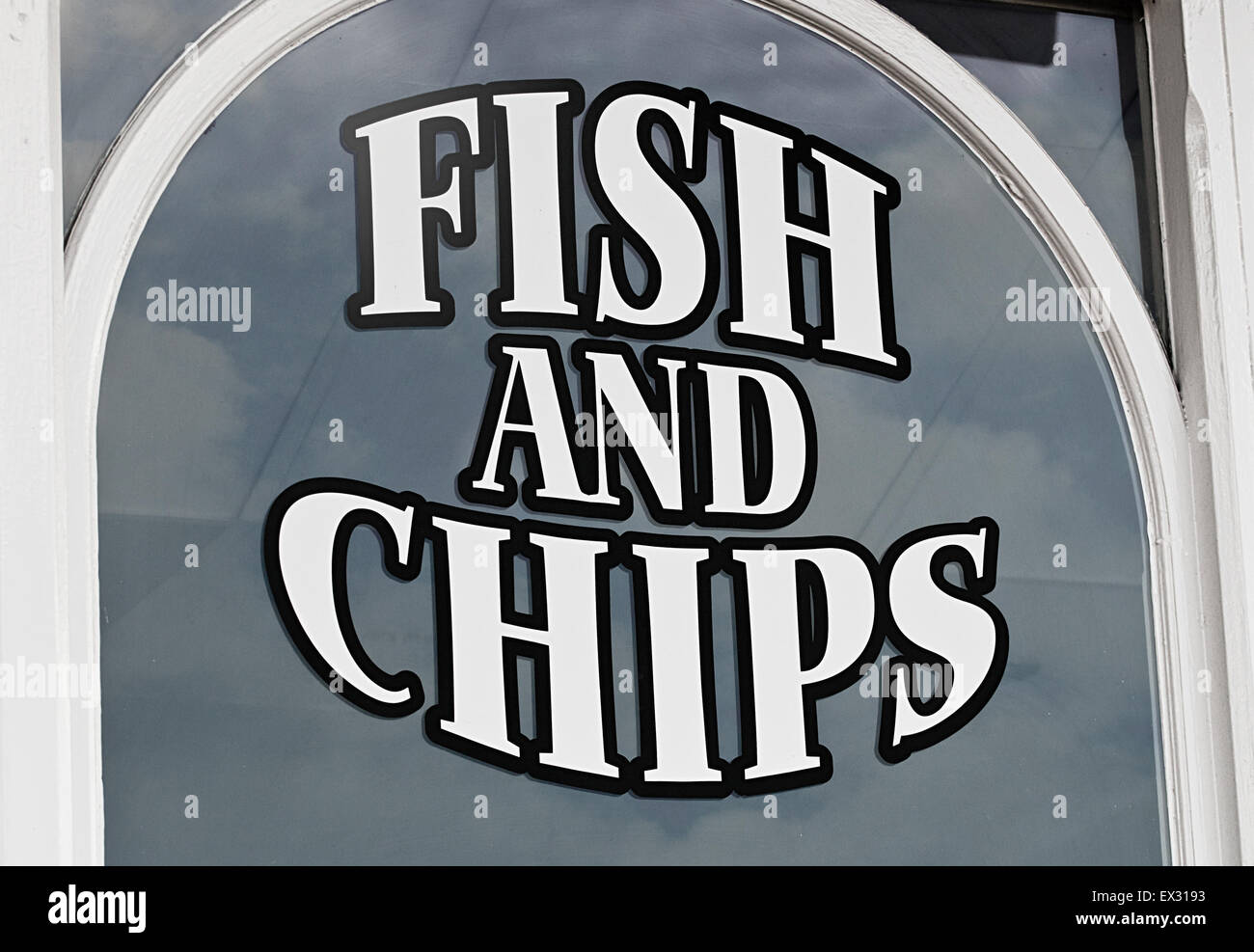 Fish and chips sign painted onto shop window to advertise the popular British Seaside delicacy to tourists Stock Photo
