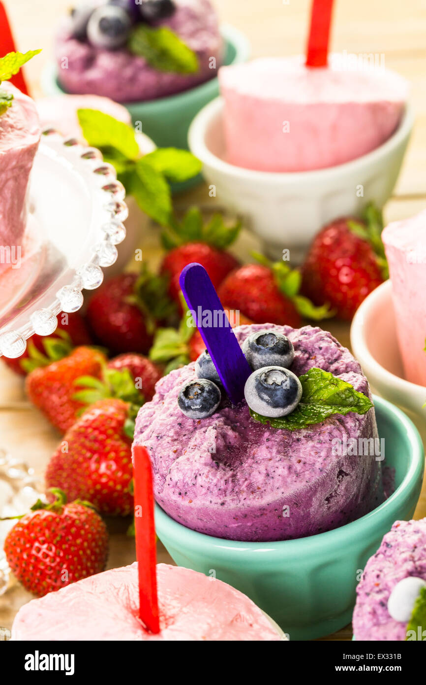 Homemade blueberry and strawberry popsicles made in plastic cups Stock