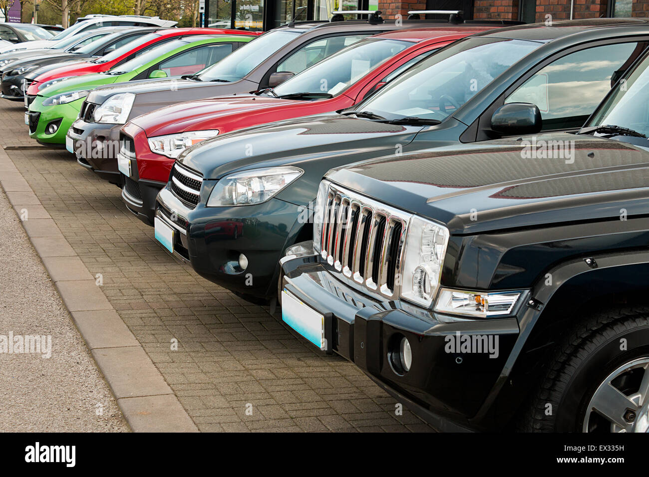 Row of used four by four motorcars also known as 4x4, SUV, off road, utility vehicle, ute or Station wagon arranged for sale on  Stock Photo