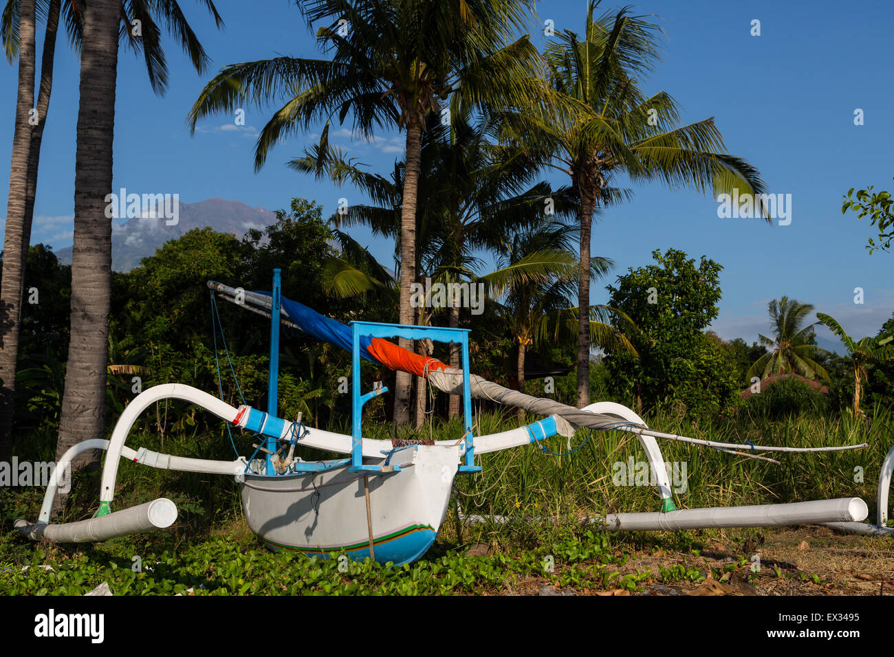 A colorful jukung boat rests on the beach in Bali, Indonesia. Stock Photo