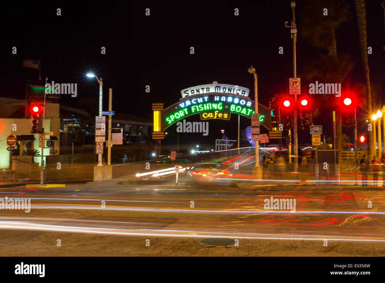 The iconic sign for the Santa Monica Pier glows neon at night. Stock Photo