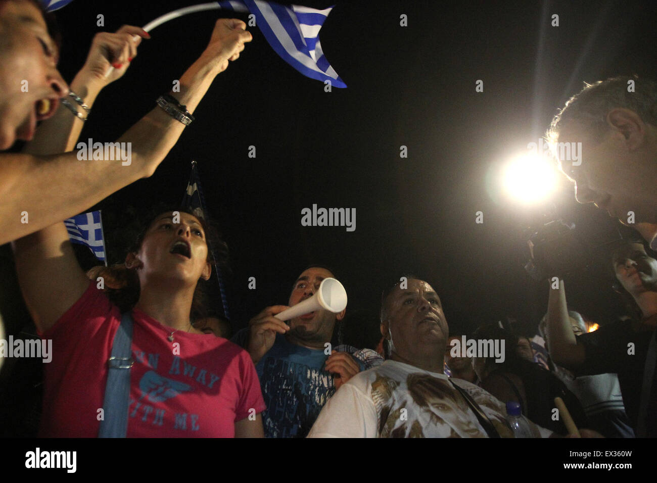 Athens. 5th July, 2015. Supporters of the No vote react after the first results of the referendum were released at Syntagma square in Athens, July 5, 2015. Greece's lenders in Euro zone will hold a conference call Monday morning after the first official results of Greek referendum showed a strong lead of NO on their offer, said the European Commission in a statement late on Sunday. Credit:  Marios Lolos/Xinhua/Alamy Live News Stock Photo