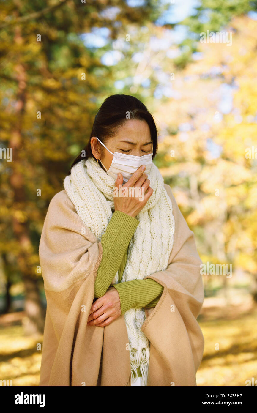 Senior Japanese woman with mask feeling sick Stock Photo