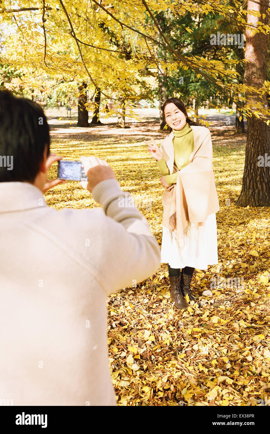 Senior Japanese couple taking pictures in a city park in Autumn Stock ...