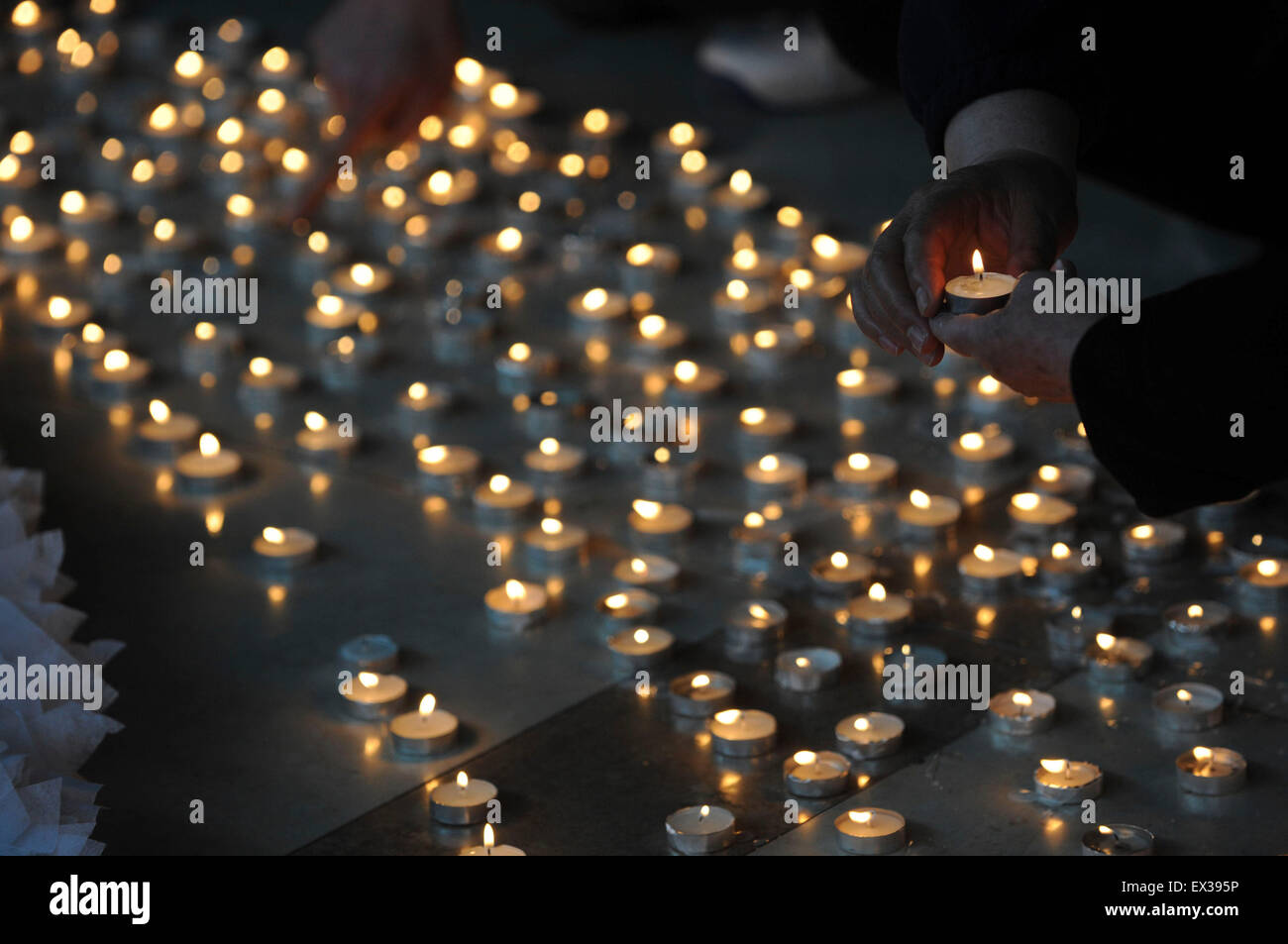 Poeple burn candles during an activity to mourn the victims who died during the Apri 14 Yushu earthquake of Qinghai province, at Stock Photo