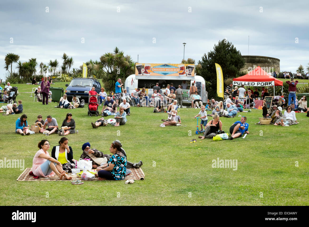 People and families relaxing on a Sunday afternoon in Summer on the Western lawns Eastbourne Sussex UK Stock Photo