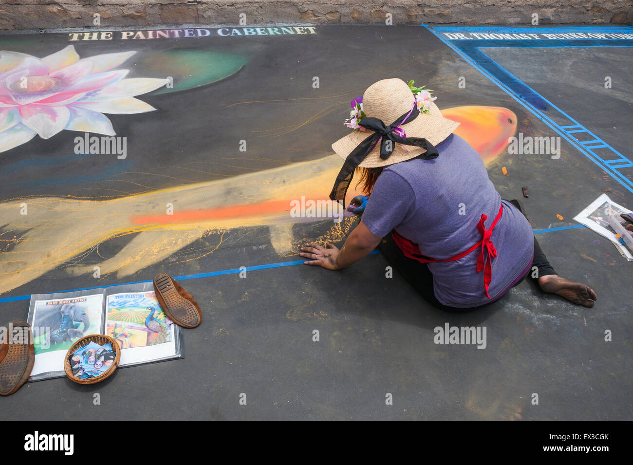 A woman artist painting with chalk at the "Old Santa Barbara Mission" during the IMadonnari