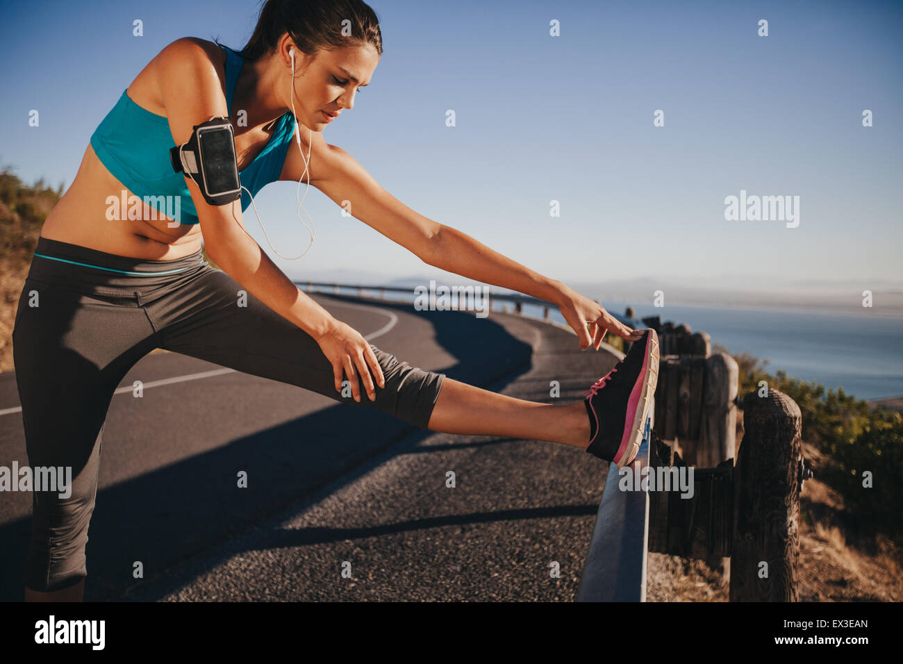Female runner stretching her legs outdoor before running. Woman doing
