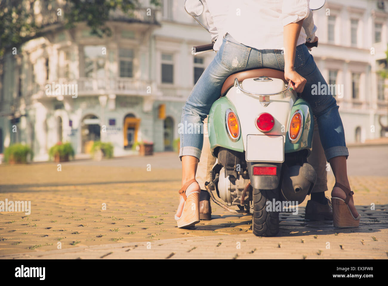 Back view portrait of a scooter with female legs in old european town Stock Photo