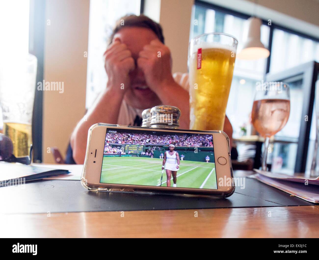 Watching Wimbledon iphone BBC iplayer in the pub Stock Photo