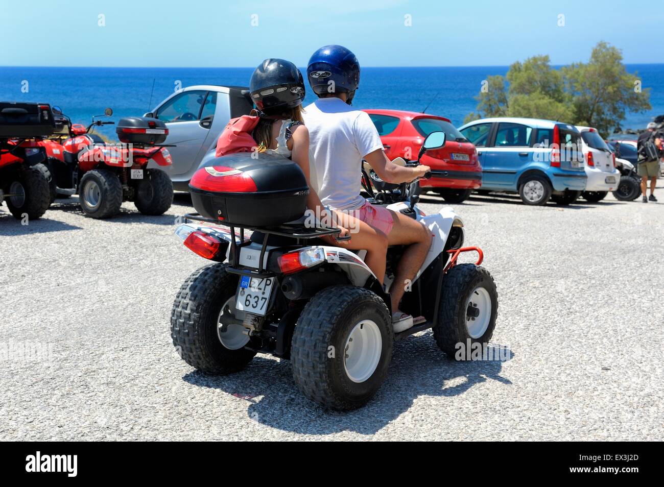 A young couple riding an ATV quad rental bike in Akrotiri Santorini