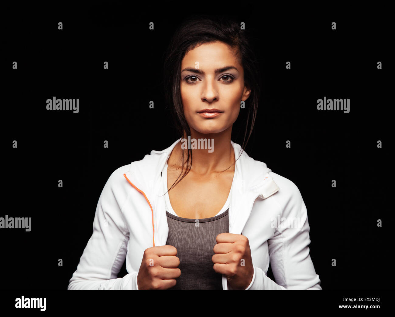 Shot of young fitness model posing in studio. Healthy young woman in sportswear standing against black background. Stock Photo