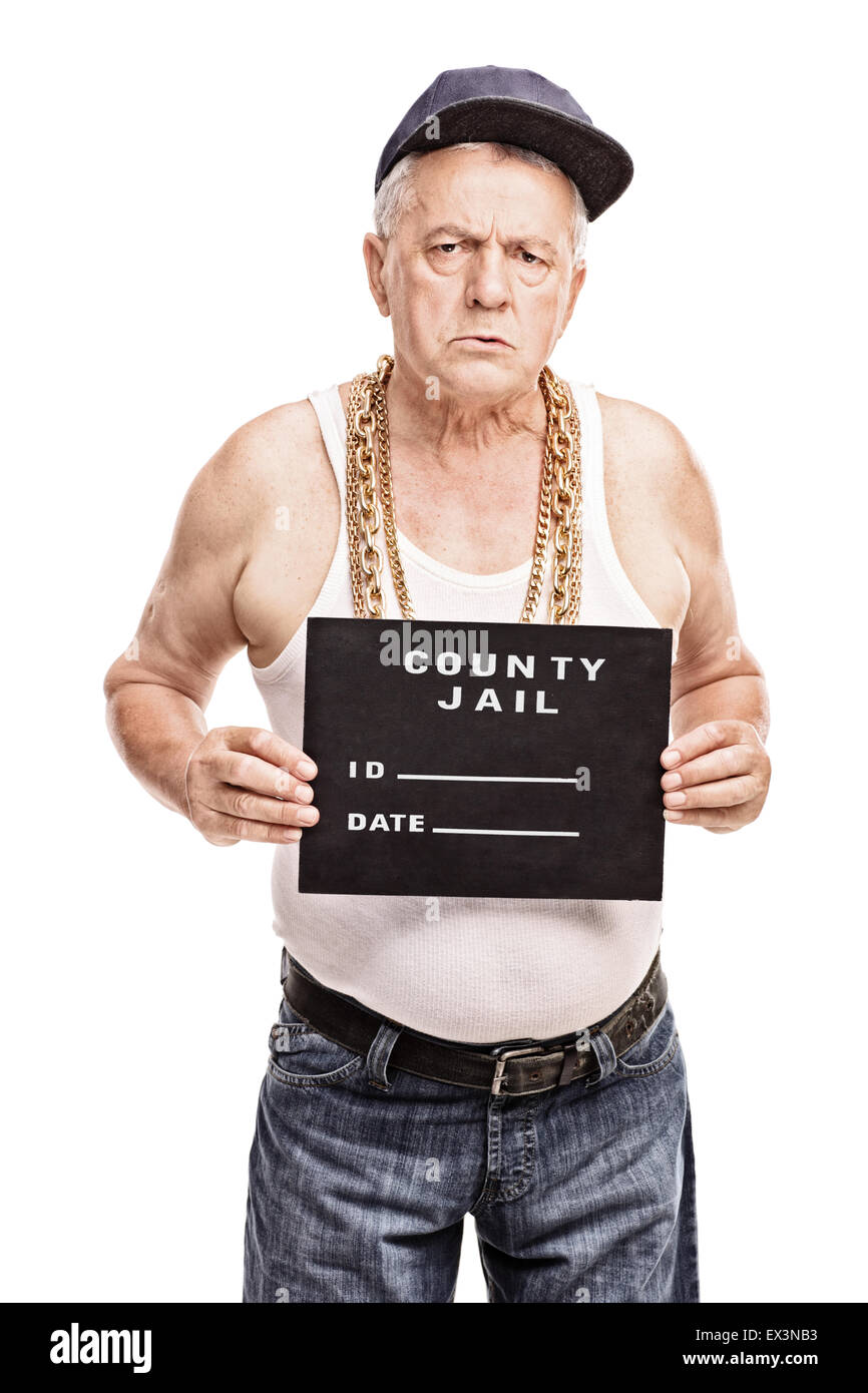 Vertical shot of a senior gangster in a hip hop outfit posing for a mug shot isolated on white background Stock Photo
