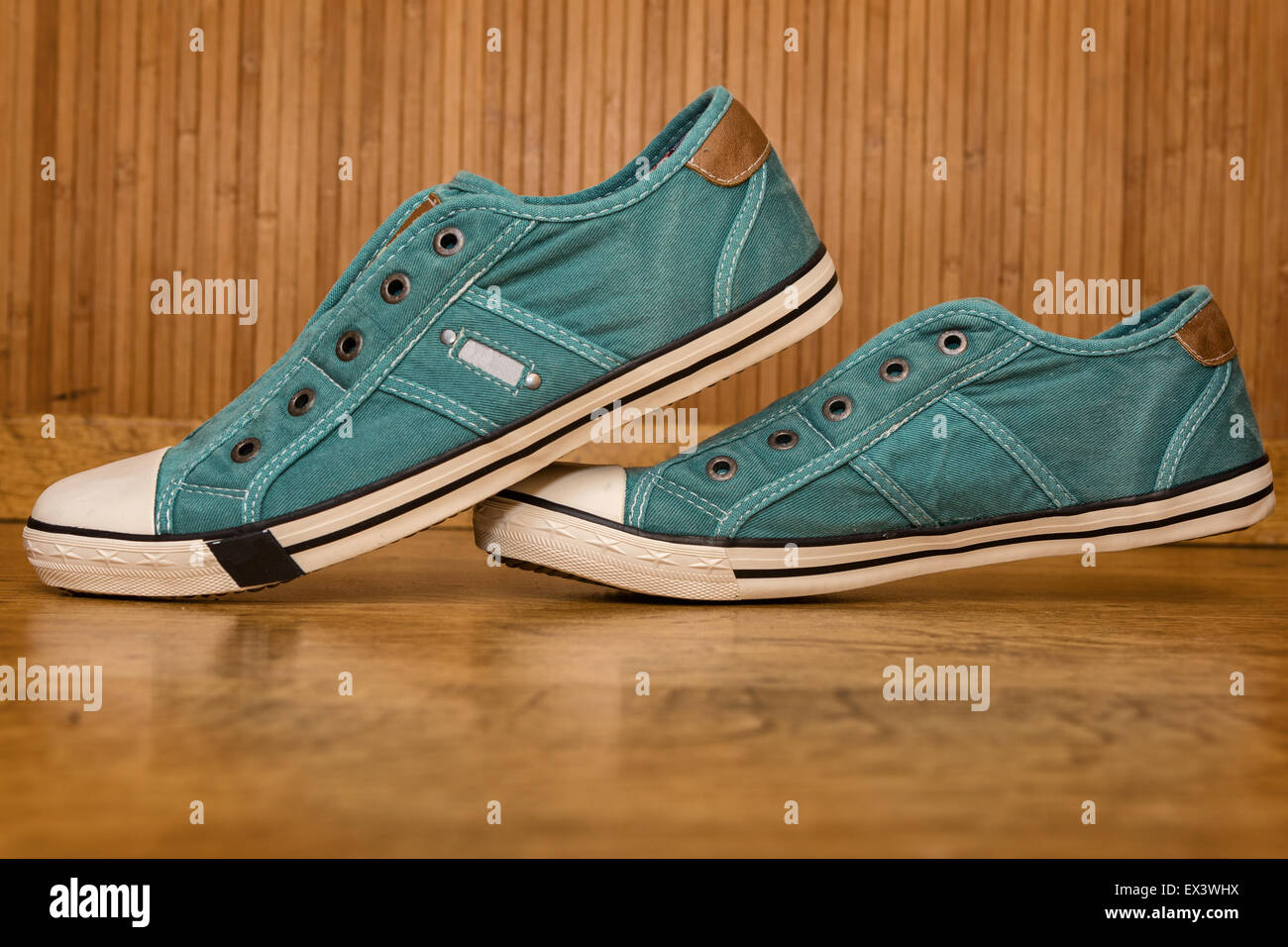 Pair of green canvas sneakers are on the yellow wood floor Stock Photo ...