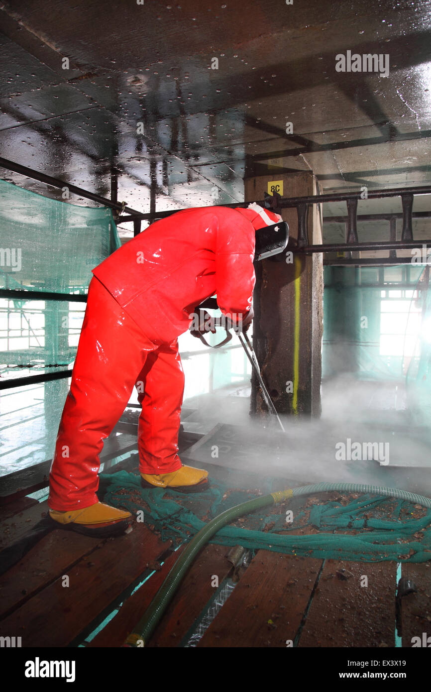 A contractor uses a high pressure water jet to remove concrete whilst repairing the support structure to the Woolwich Ferry vehicle ramp. London, UK. Stock Photo