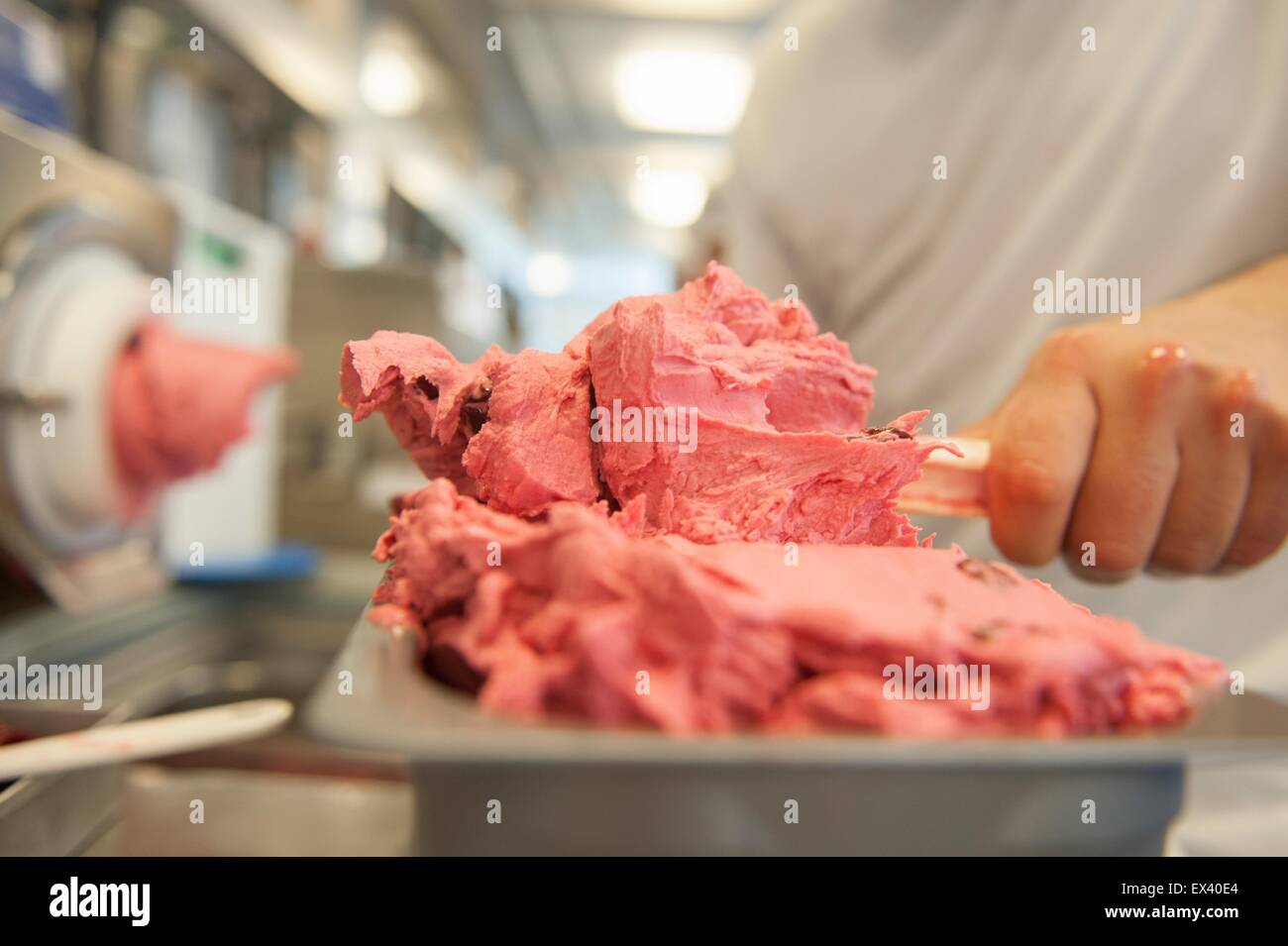 Berlin, Germany. 01st July, 2015. An employee fills a cooling container with cherry ice cream at ice cream manufacturer Florida Eis in Berlin, Germany, 01 July 2015. Around 200 employees are involved in the production and selling of about 80 different kinds of ice cream. Photo: Paul Zinken/dpa/Alamy Live News Stock Photo