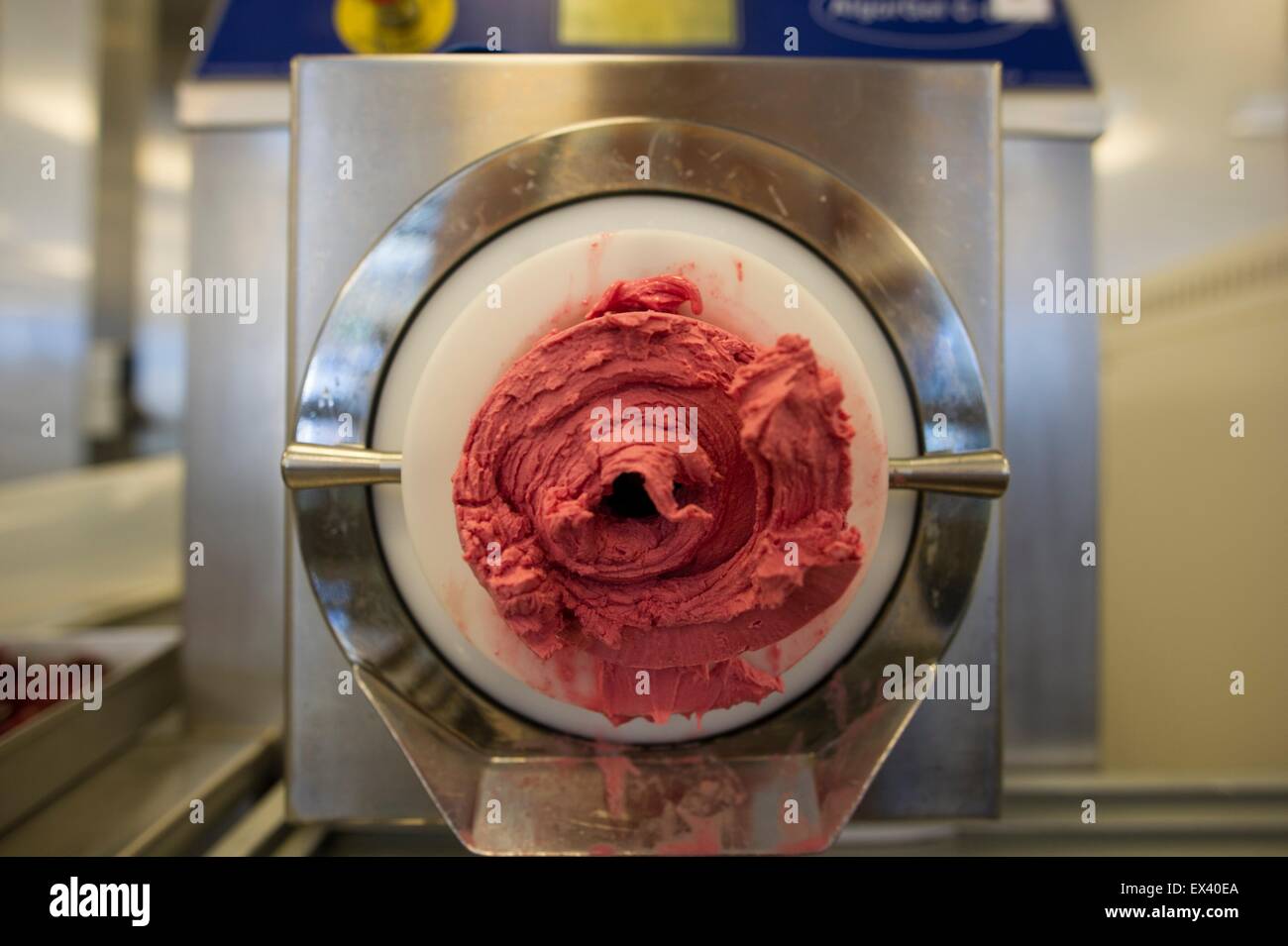 Berlin, Germany. 01st July, 2015. Cherry ice cream comes out of a machine at ice cream manufacturer Florida Eis in Berlin, Germany, 01 July 2015. Around 200 employees are involved in the production and selling of about 80 different kinds of ice cream. Photo: Paul Zinken/dpa/Alamy Live News Stock Photo
