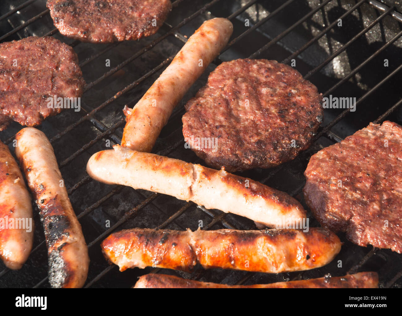burgers and sausages on a barbecue Stock Photo Alamy