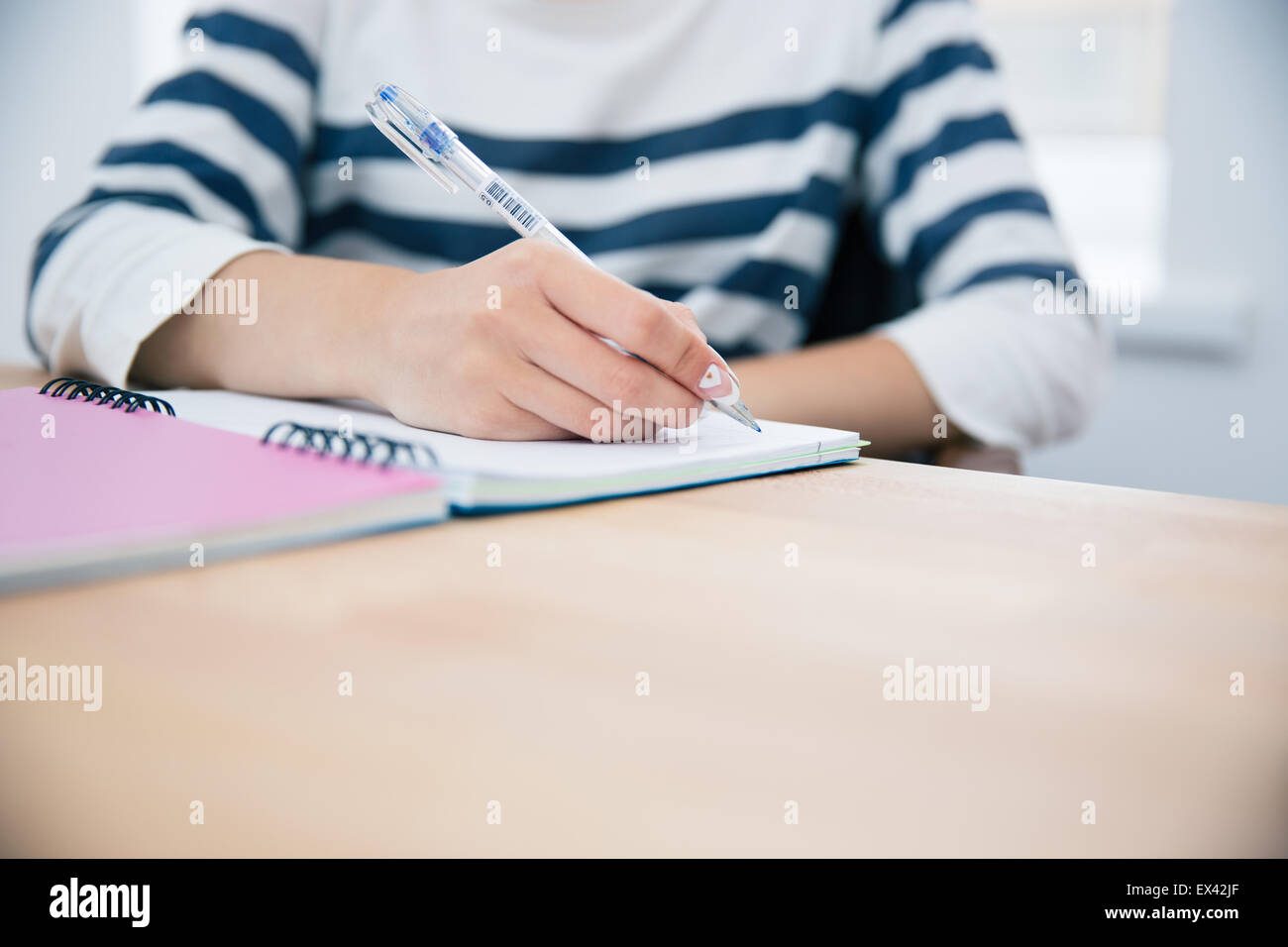 CLoseup portrait of a woman writing in notepad at office Stock Photo ...