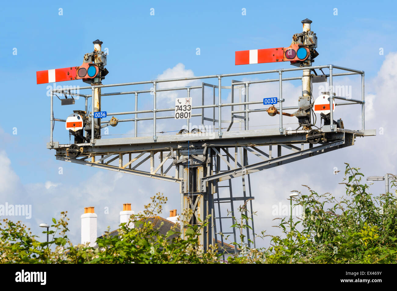 Semaphore stop signals on a signal gantry on a British railway, both in the stop position, in Southern England, UK. Stock Photo