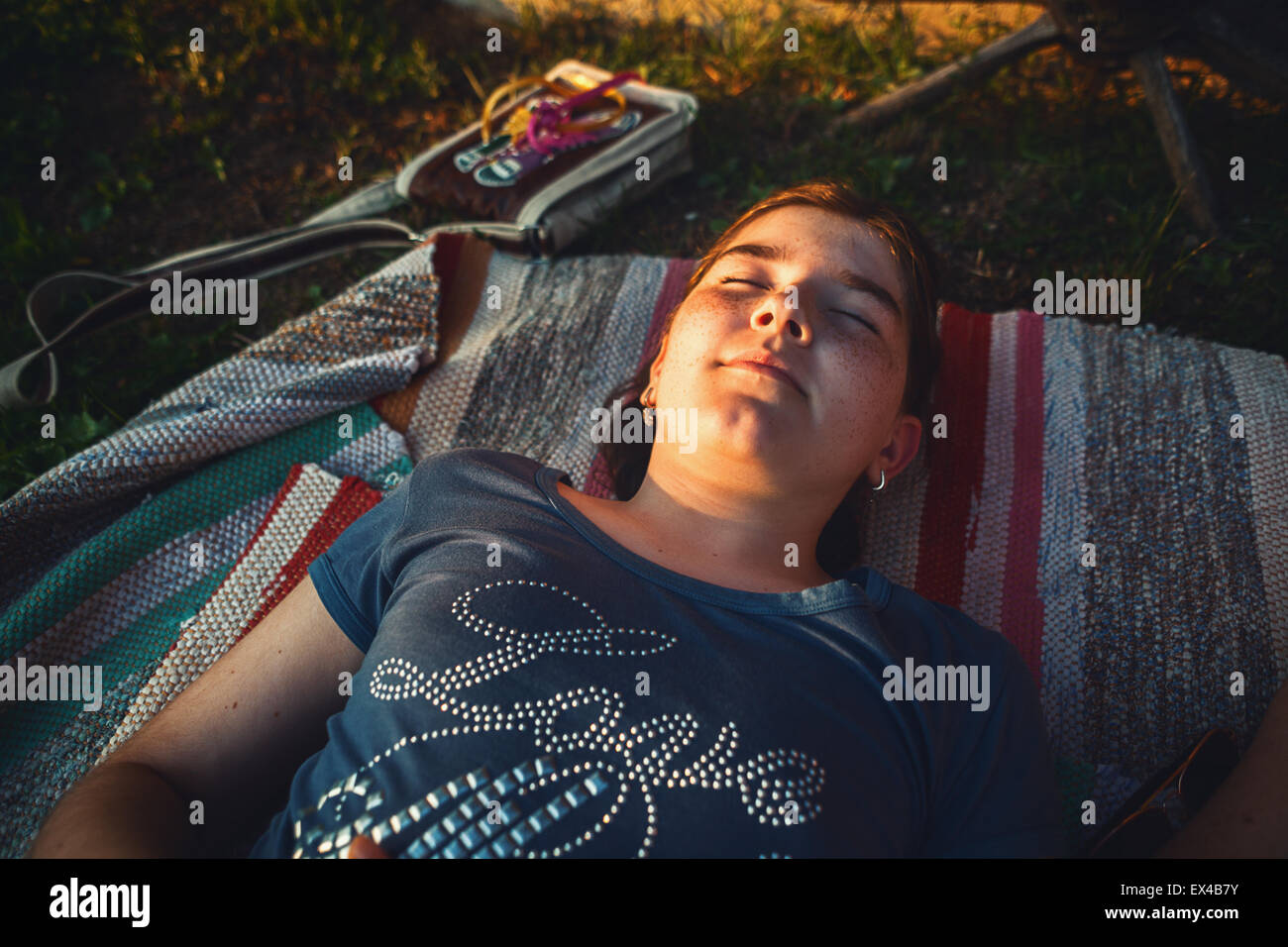 Young girl resting in nature at sunset. Stock Photo