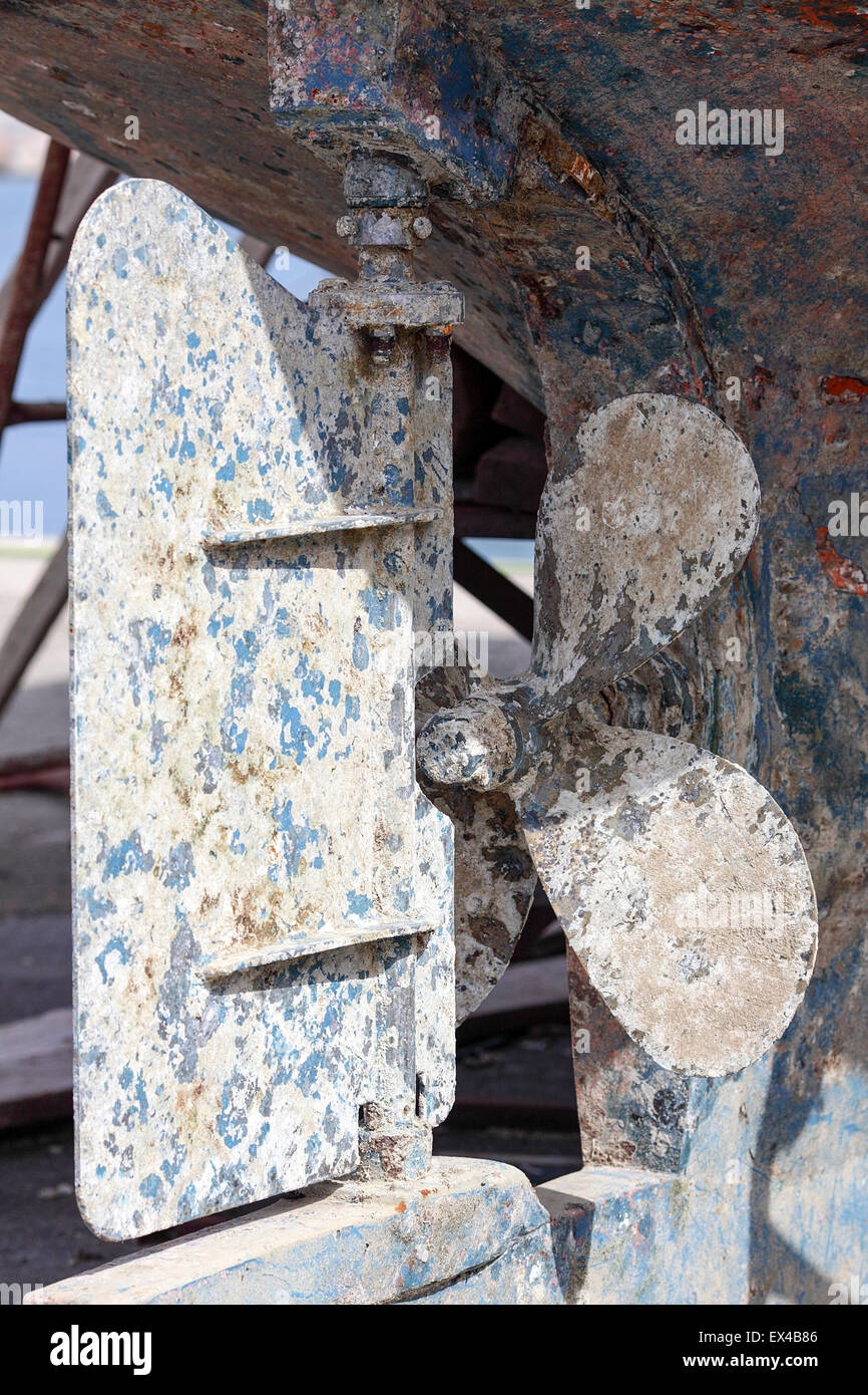 Exposed rudder and propeller of large boat undergoing restoration in Rethymnon boatyard. Stock Photo