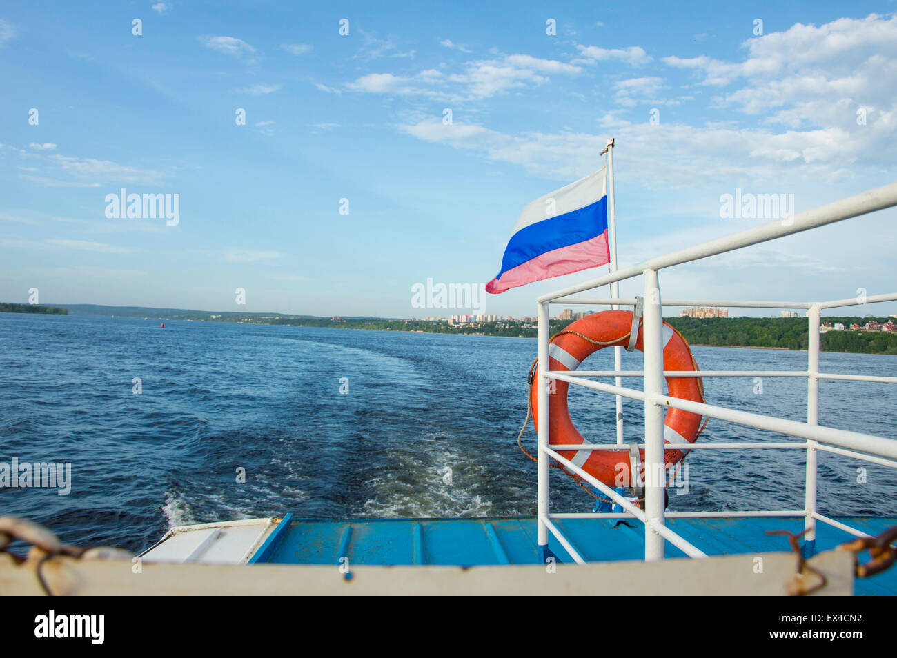 closeup of the flag on the stern of a recreational boat and the city in the background Stock Photo