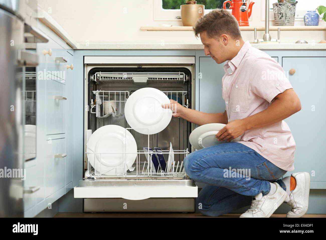 Man Loading Dishwasher In Kitchen Stock Photo Alamy