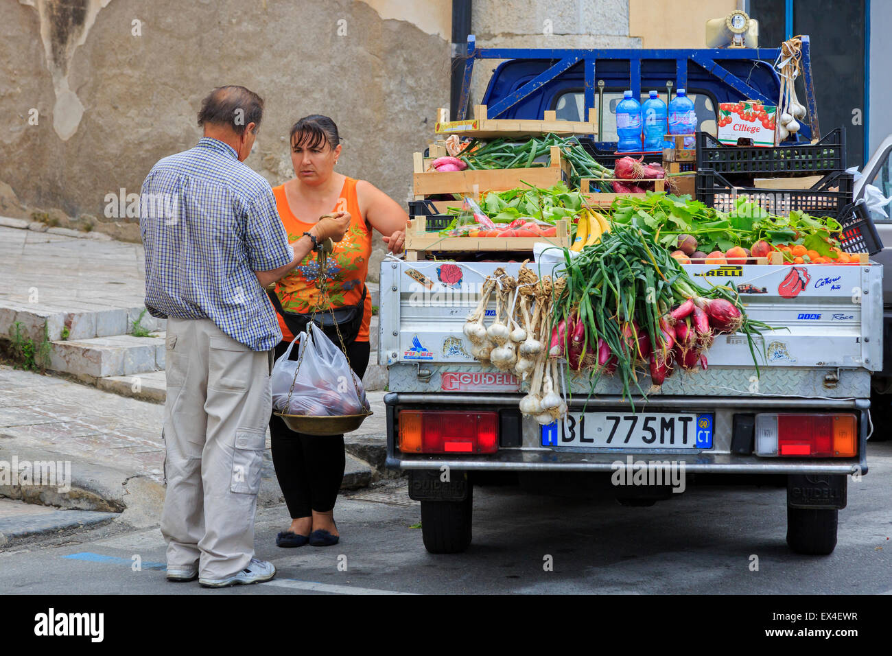 Woman buying fresh fruit and vegetables from a street vendor, Sicily, Italy Stock Photo