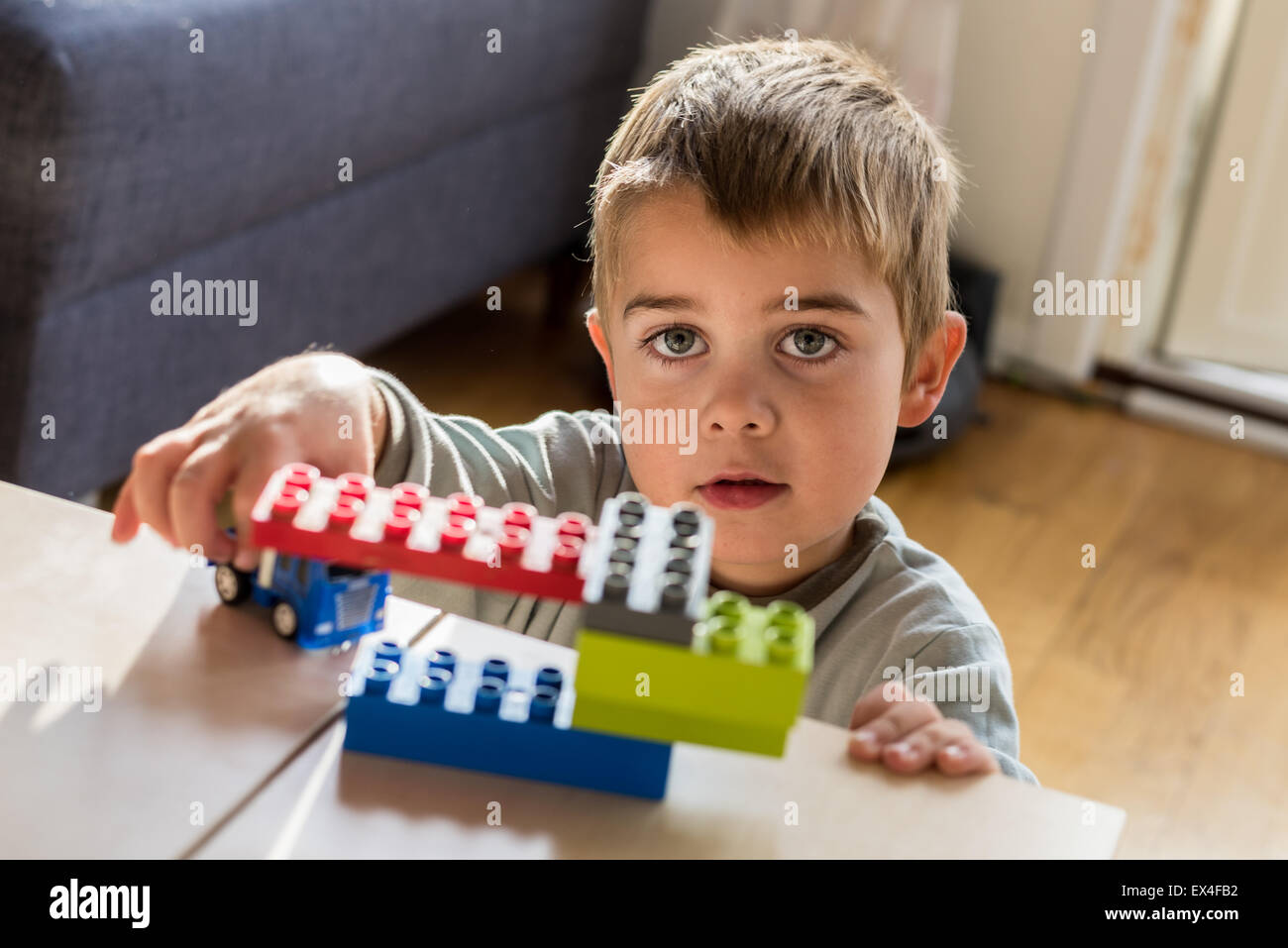 Happy boy playing with his toys Stock Photo - Alamy