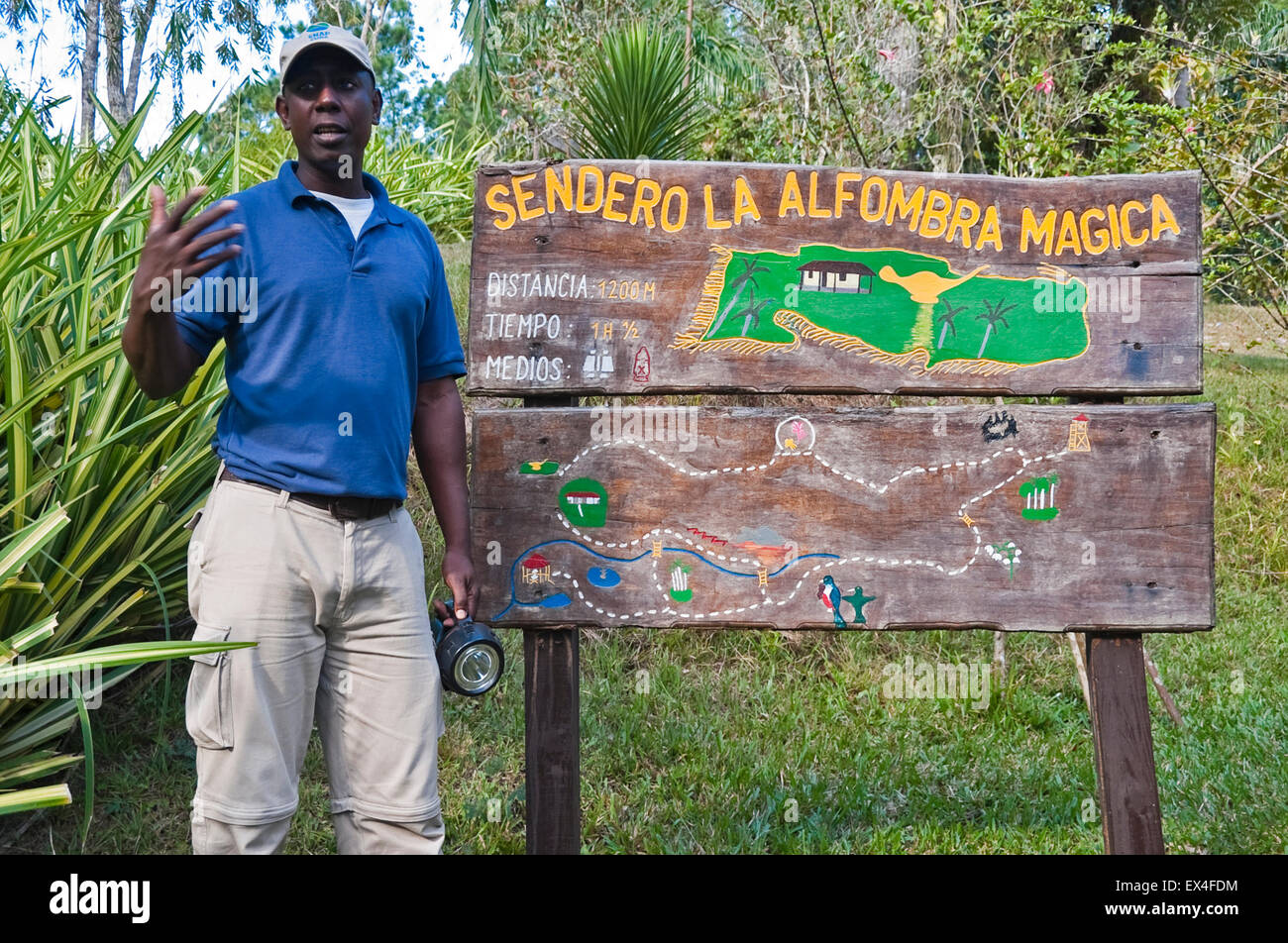 Horizontal portait of a tour guide infront of an information board in Topes de Collantes National Park in Cuba. Stock Photo